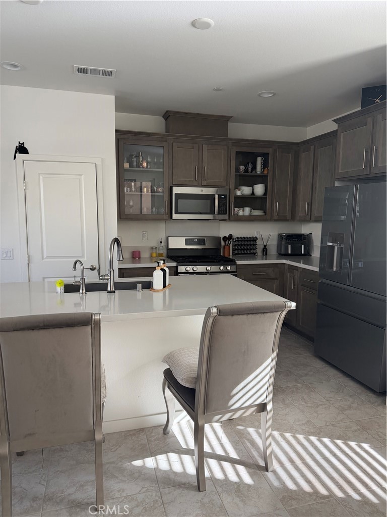32703 Brunello Way Temecula, CA 92591 - Photo 5 of 26 a kitchen with stainless steel appliances granite countertop a sink a stove a refrigerator cabinets and chairs