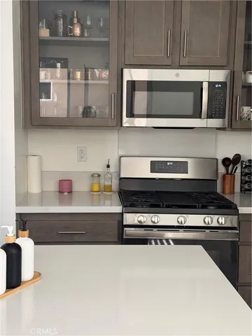 a kitchen with stainless steel appliances a stove and a microwave