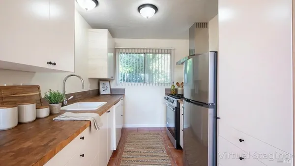 a kitchen with stainless steel appliances granite countertop a refrigerator a sink a stove and a refrigerator with wooden floor