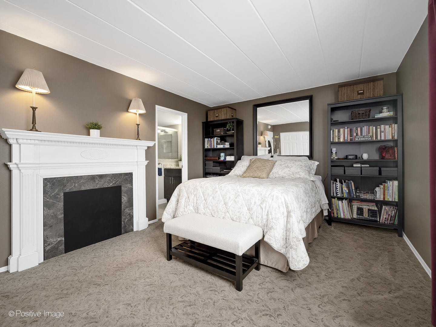 100 West Butterfield Road, Unit 401N Elmhurst, IL 60126 - Photo 18 of 29 a bed sitting in a spacious bedroom next to a fireplace and window
