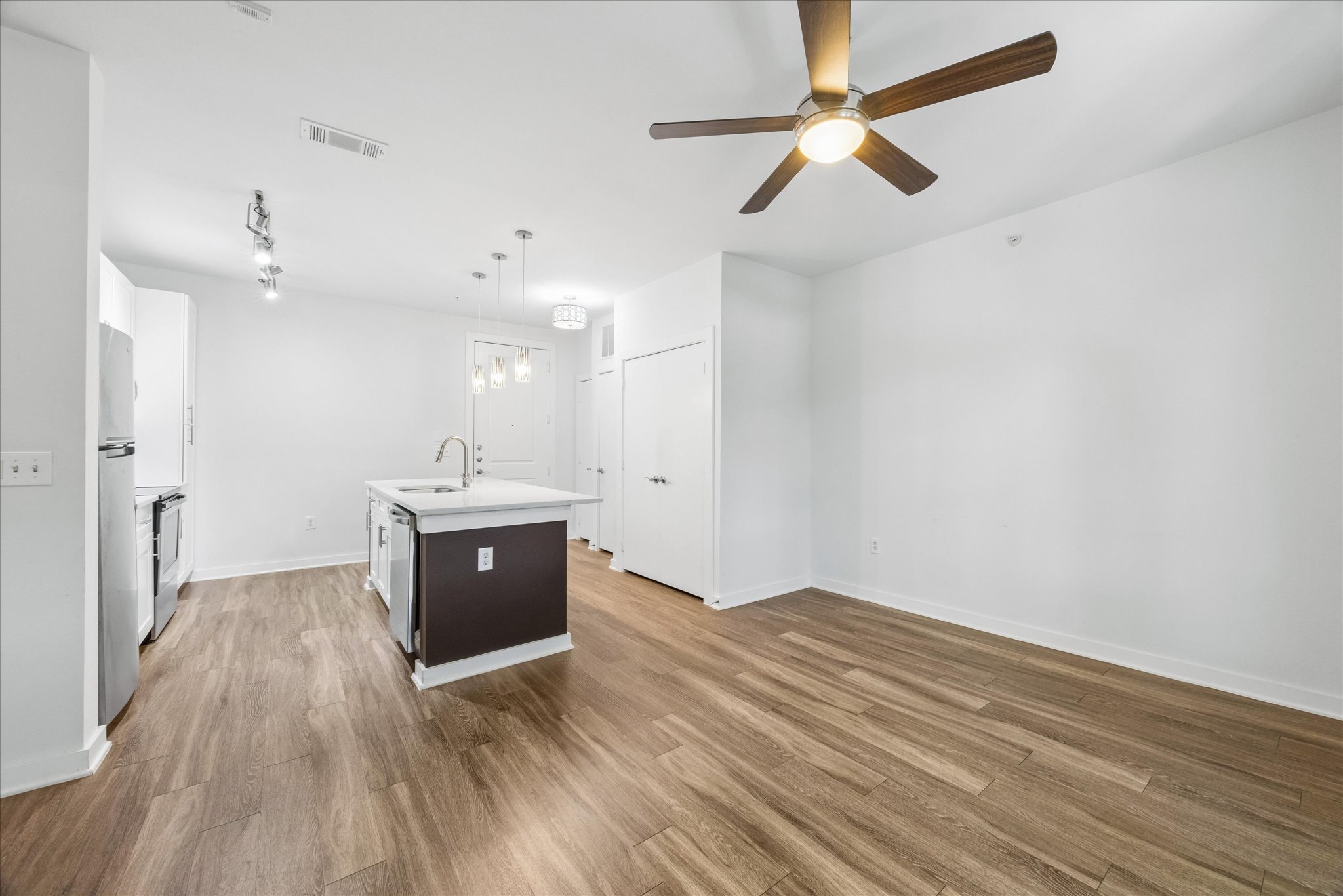 1900 Barton Springs Road, Unit 4041 Austin, TX 78704 - Photo 16 of 35 An inviting open-concept layout features rich wood flooring and a contemporary kitchen island.