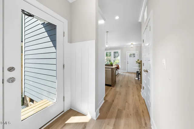 a view of a hallway with a livingroom and a bathroom with sink
