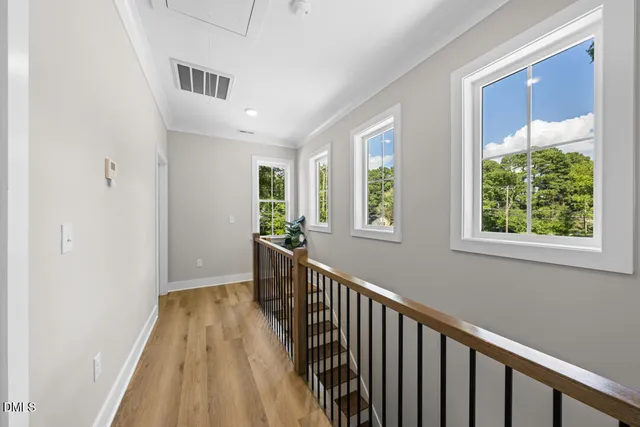 a view of a hallway with wooden floor and windows