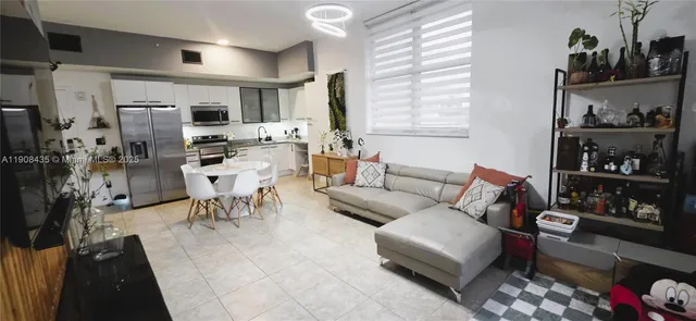 a living room with furniture a flat screen tv and a large window