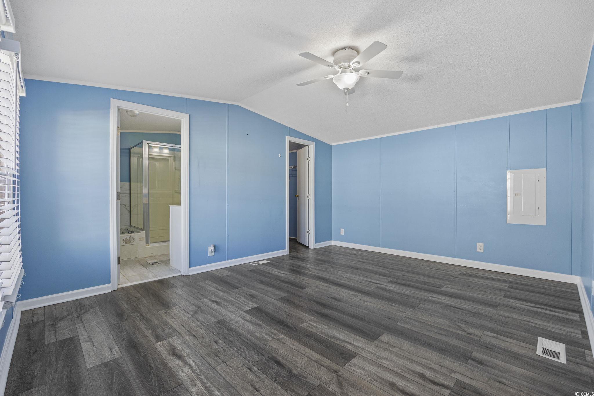 2000 Highway 15 Myrtle Beach, SC 29577 - Photo 12 of 27 Unfurnished bedroom with dark wood-type flooring, a ceiling fan, lofted ceiling, and ensuite bath