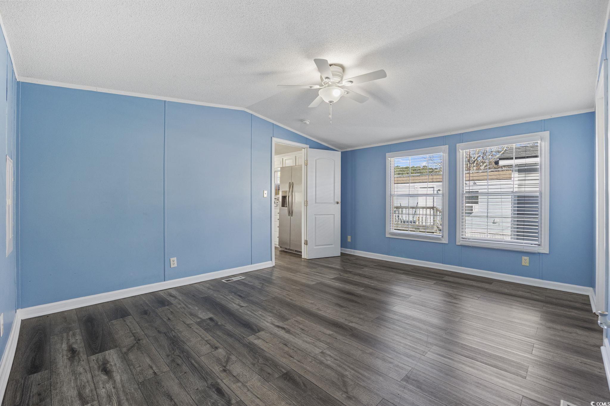 2000 Highway 15 Myrtle Beach, SC 29577 - Photo 13 of 27 Empty room with lofted ceiling, a textured ceiling, dark wood-type flooring, and ceiling fan