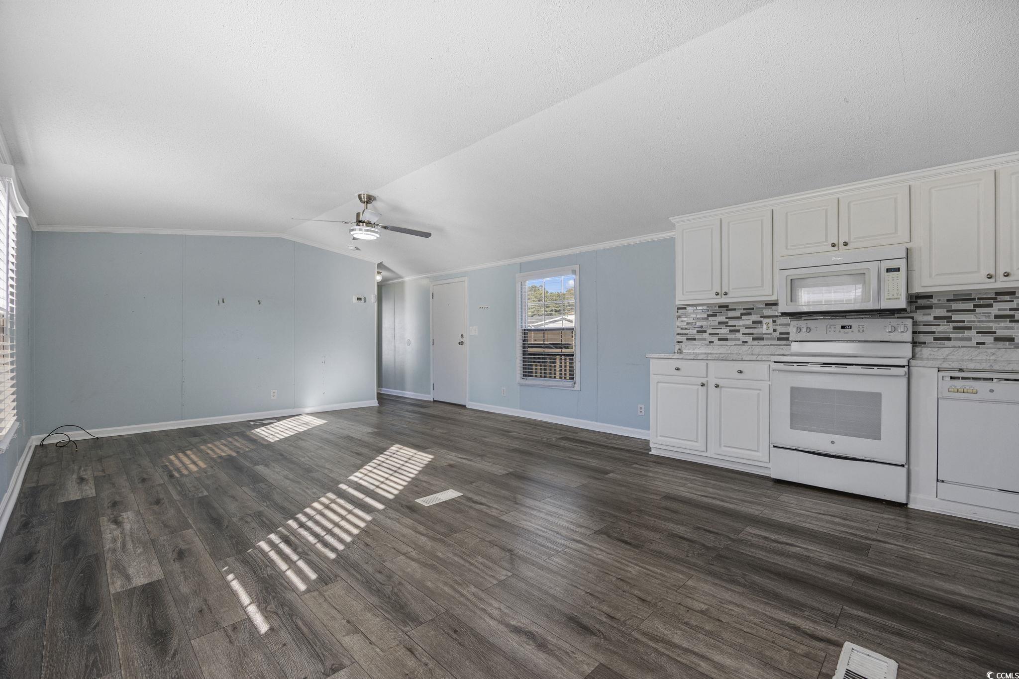 2000 Highway 15 Myrtle Beach, SC 29577 - Photo 27 of 27 Kitchen featuring white appliances, white cabinetry, vaulted ceiling, dark wood finished floors, and open floor plan