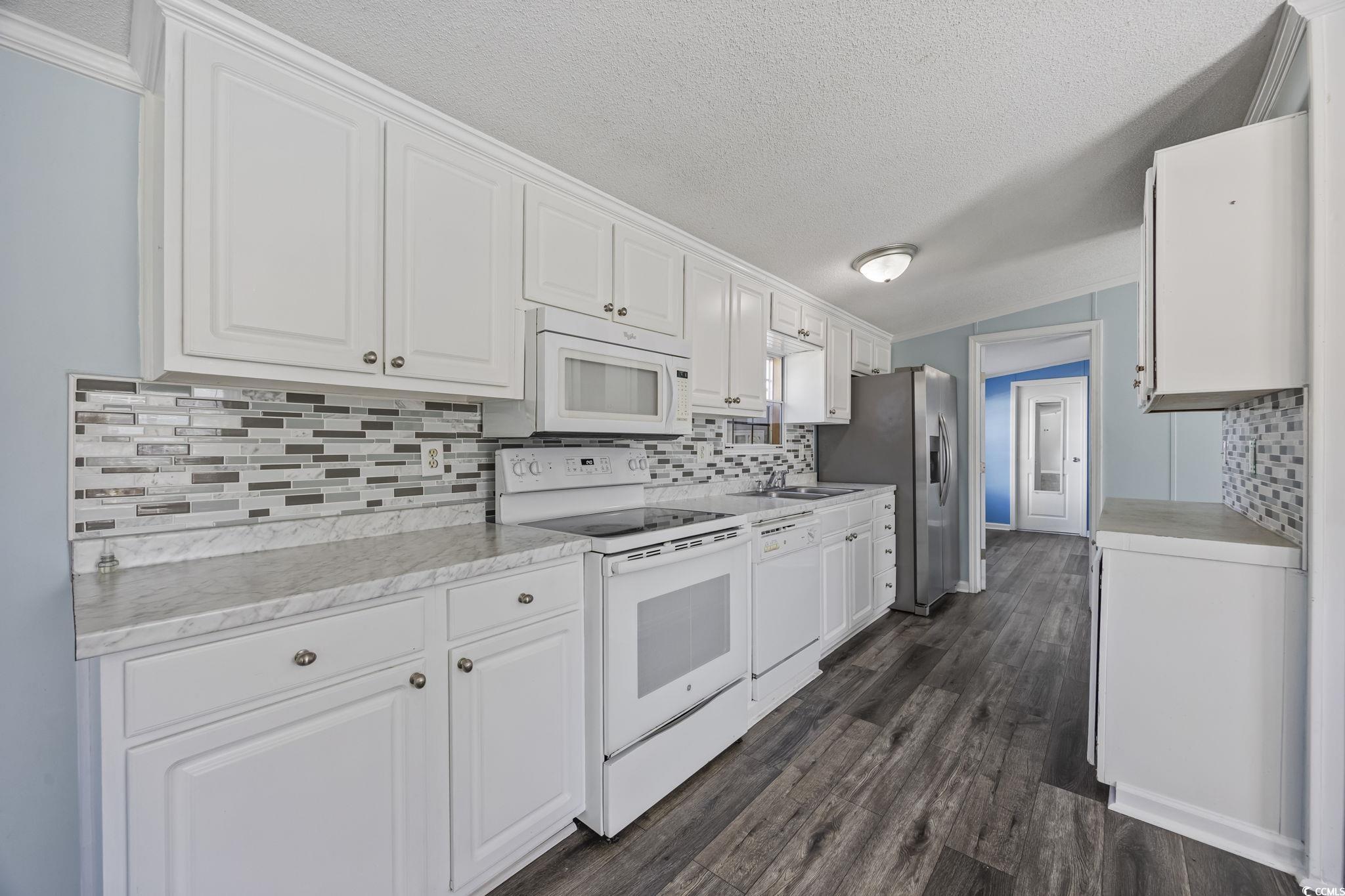 2000 Highway 15 Myrtle Beach, SC 29577 - Photo 8 of 27 Kitchen featuring white appliances, light countertops, white cabinets, a textured ceiling, and lofted ceiling