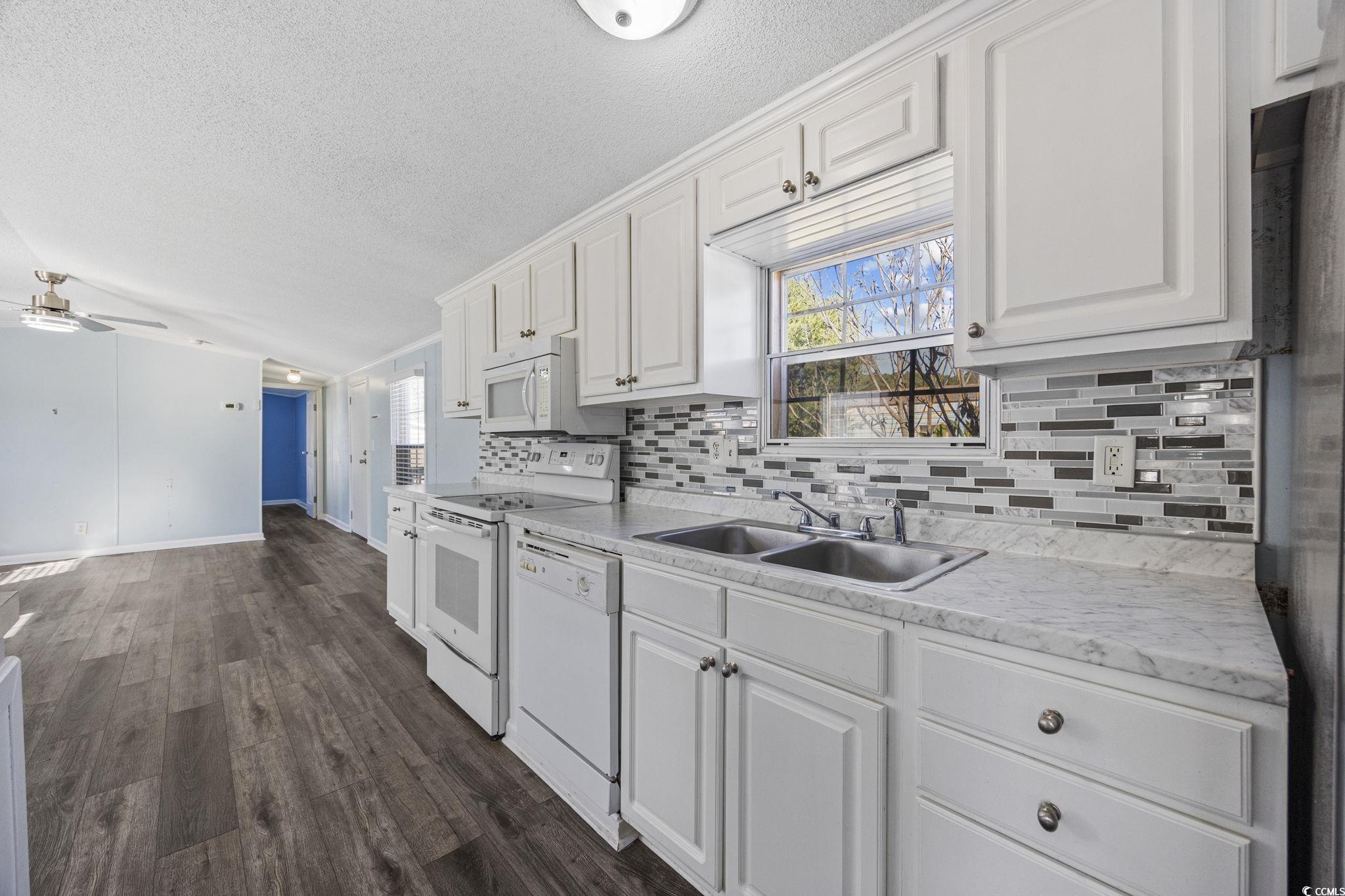 2000 Highway 15 Myrtle Beach, SC 29577 - Photo 9 of 27 Kitchen with light countertops, white cabinets, white appliances, healthy amount of natural light, and a textured ceiling