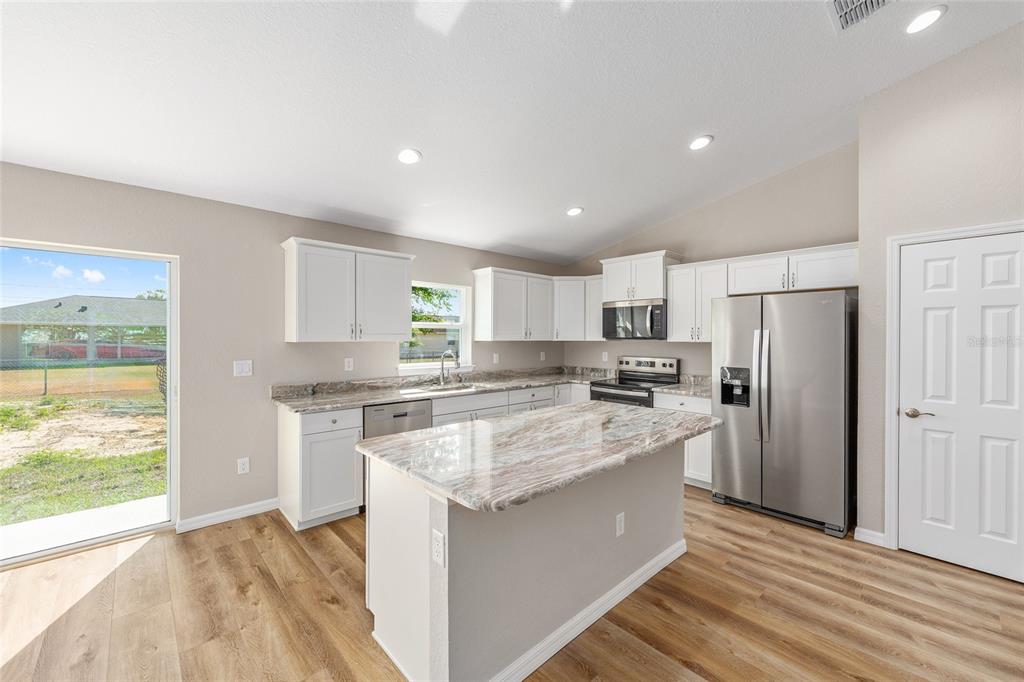 7724 North Manville Road Citrus Springs, FL 34434 - Photo 11 of 20 a large kitchen with a center island wooden floor and stainless steel appliances