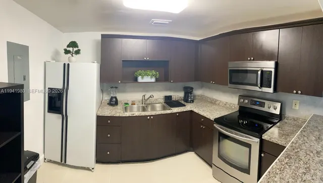 a kitchen with stainless steel appliances granite countertop a refrigerator stove and sink