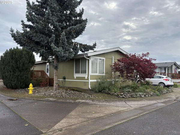 a front view of a house with garden and parking
