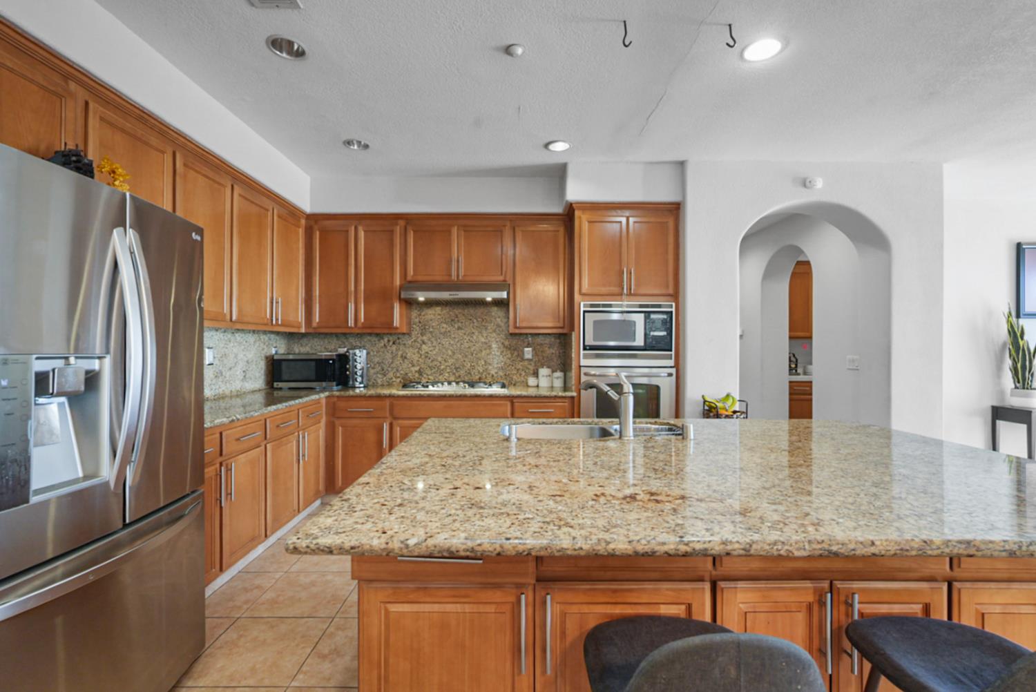 16501 Upper Pasture Lathrop, CA 95330 - Photo 14 of 41 a kitchen with stainless steel appliances granite countertop a sink refrigerator and cabinets