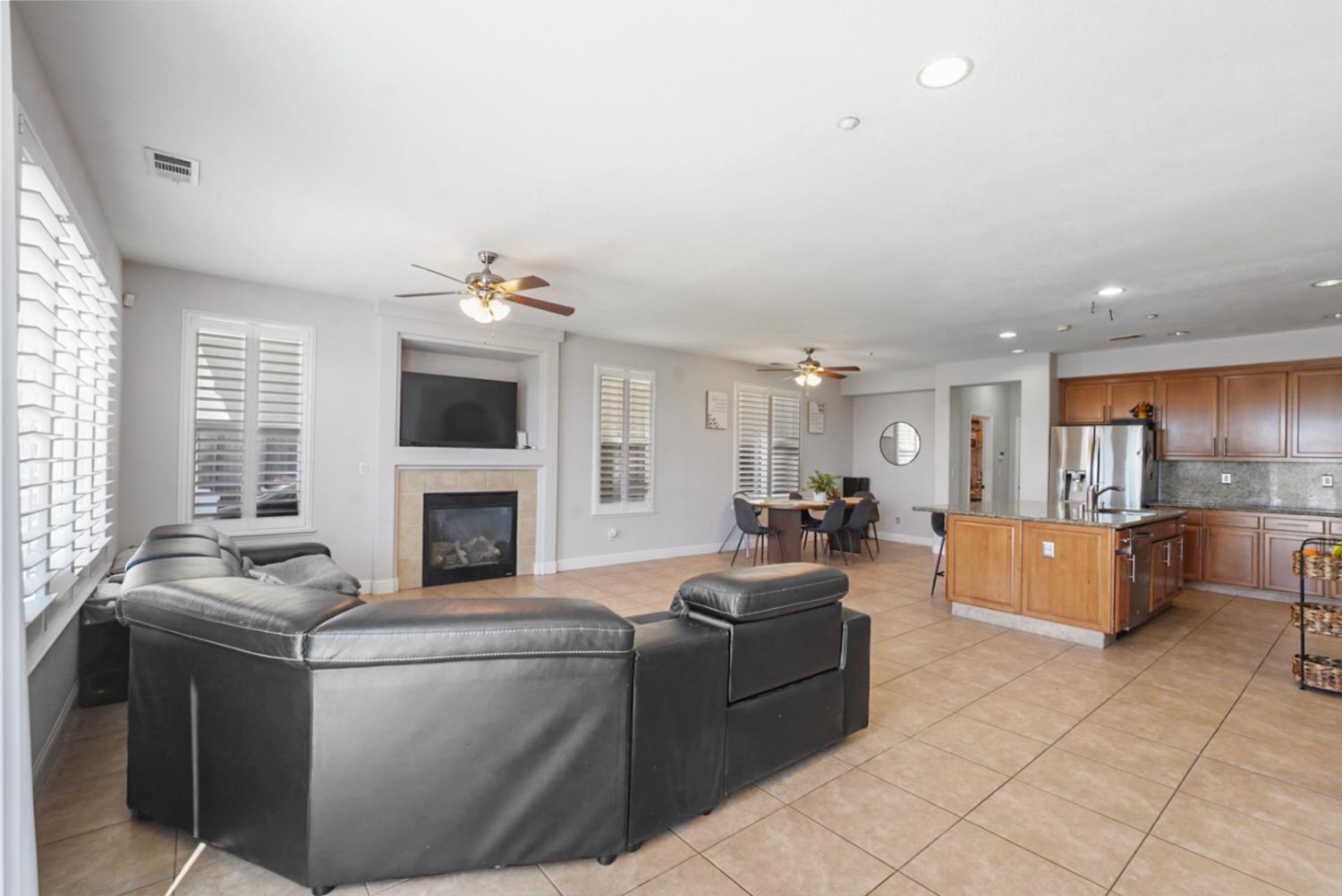 16501 Upper Pasture Lathrop, CA 95330 - Photo 17 of 41 a living room with furniture a fireplace and a kitchen view