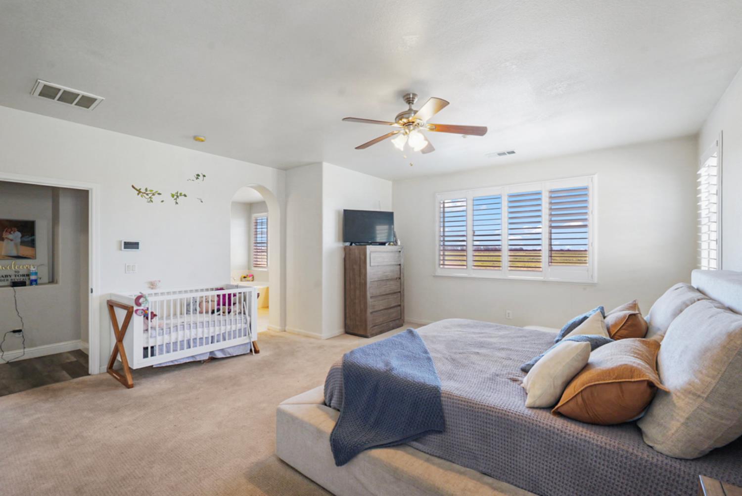 16501 Upper Pasture Lathrop, CA 95330 - Photo 26 of 41 a bedroom with a bed a couch and a chandelier