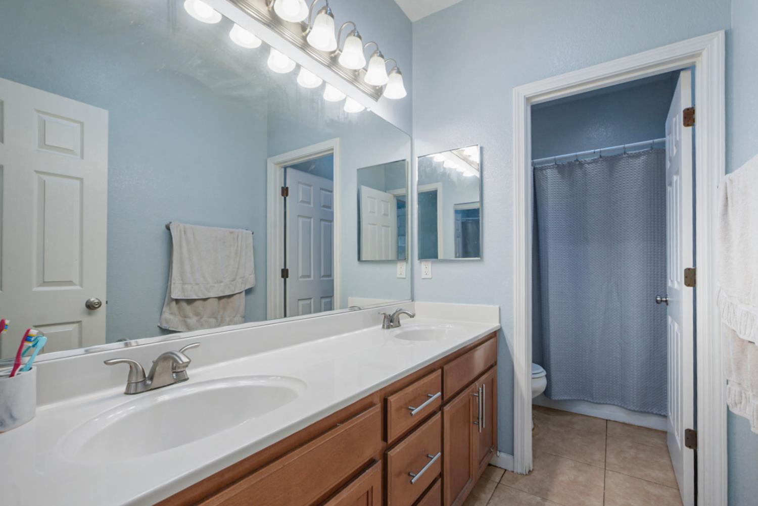 16501 Upper Pasture Lathrop, CA 95330 - Photo 30 of 41 a bathroom with a double vanity sink and a mirror