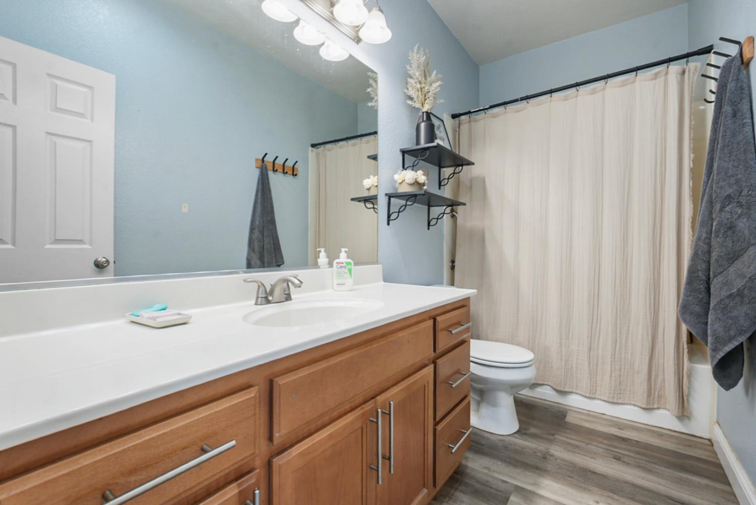 16501 Upper Pasture Lathrop, CA 95330 - Photo 7 of 41 a bathroom with a sink a toilet and a mirror