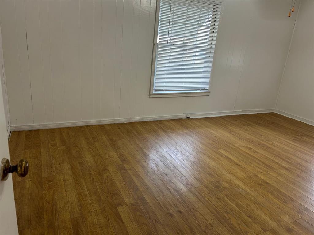 1411 James Street Sweetwater, TX 79556 - Photo 4 of 10 an empty room with wooden floor and windows
