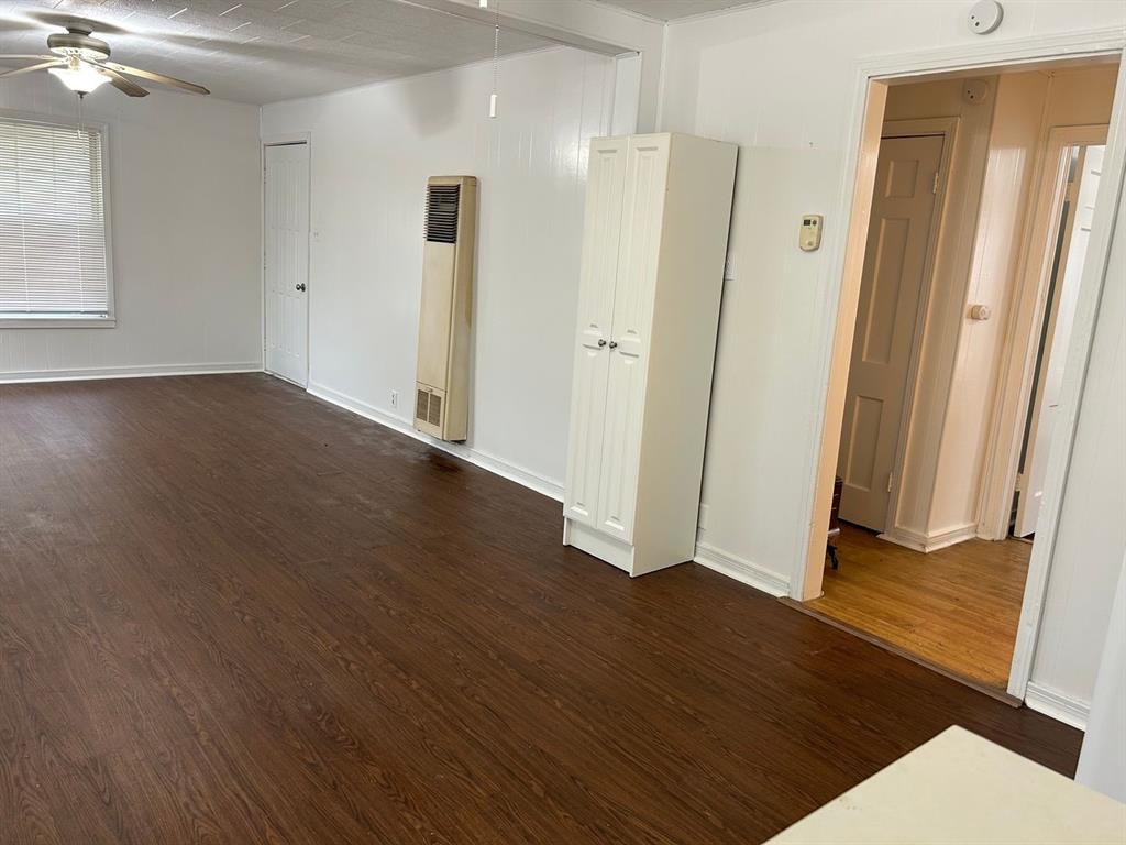 1411 James Street Sweetwater, TX 79556 - Photo 5 of 10 an empty room with wooden floor and a bathroom