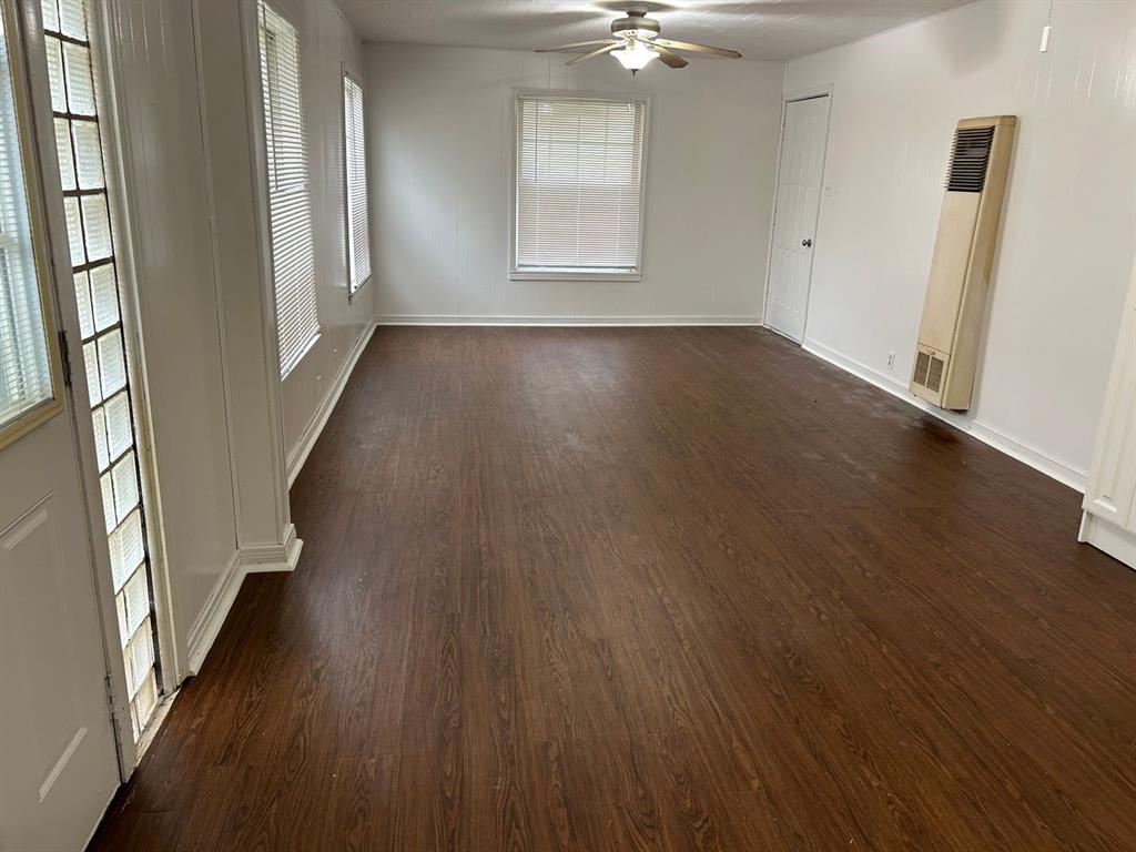 1411 James Street Sweetwater, TX 79556 - Photo 6 of 10 an empty room with wooden floor and windows