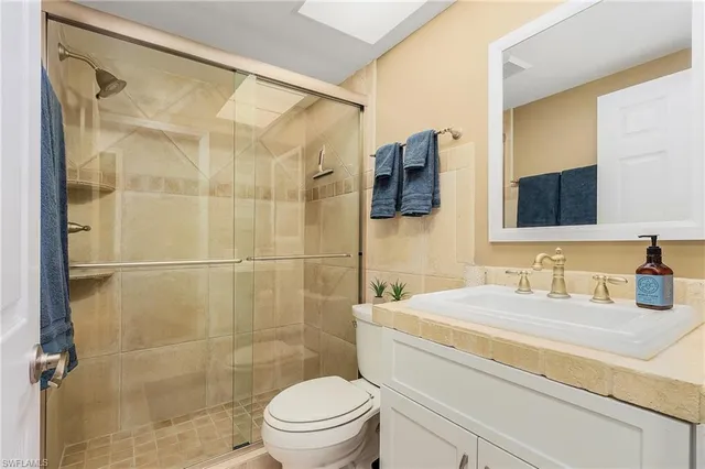 a bathroom with a sink toilet a mirror and shower