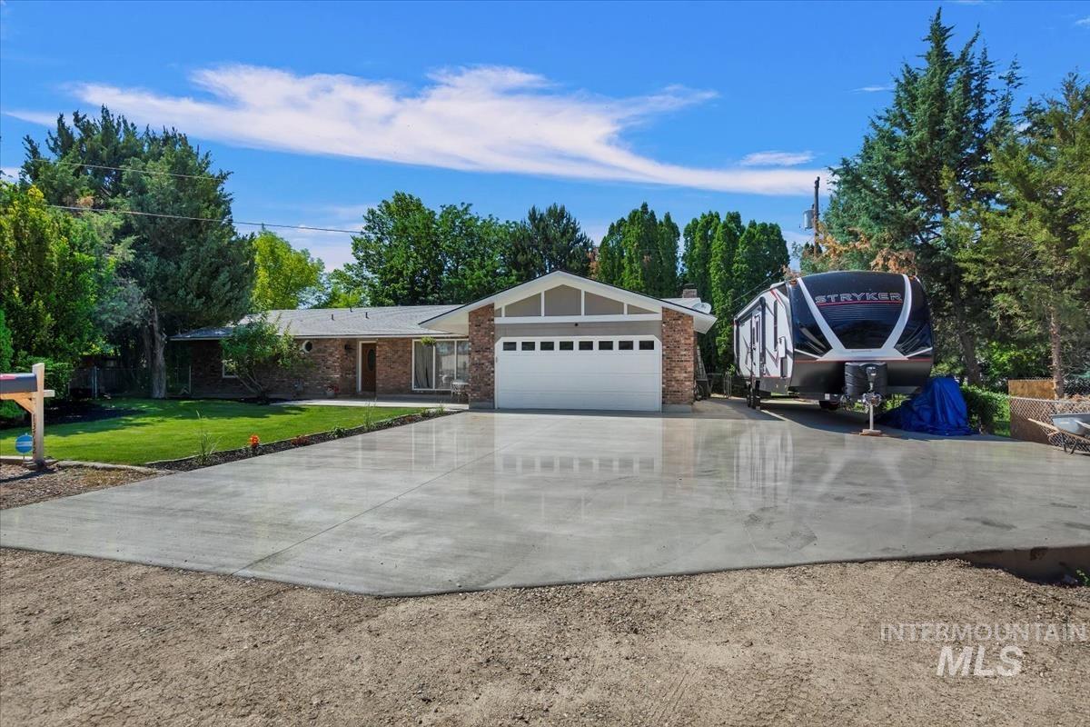 13712 Jarett Street Caldwell, ID 83607 - Photo 1 of 39 Ranch-style house with driveway, a front lawn, brick siding, a garage, and a chimney