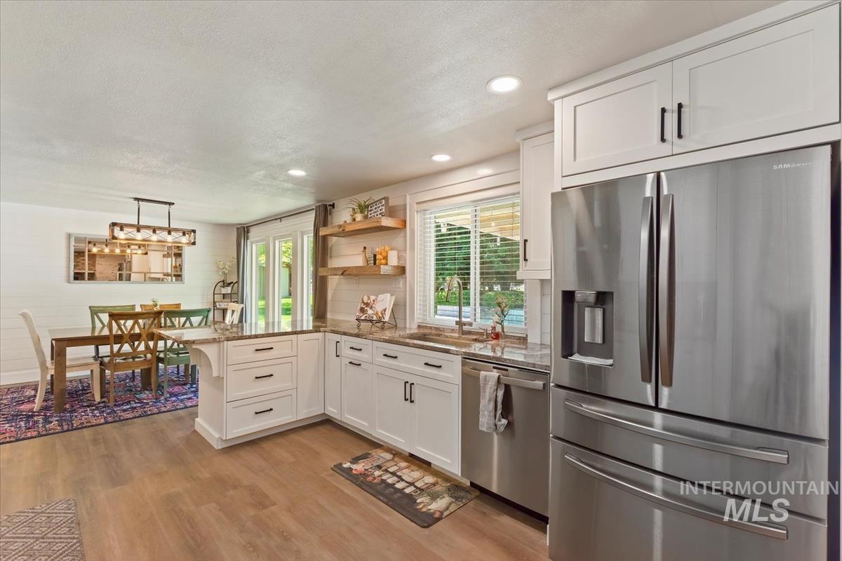13712 Jarett Street Caldwell, ID 83607 - Photo 17 of 39 Kitchen featuring stainless steel appliances, a peninsula, white cabinetry, open shelves, and recessed lighting