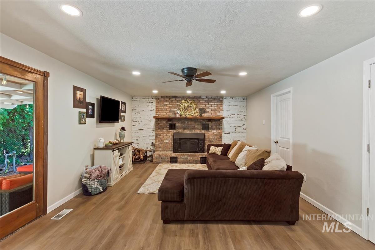 13712 Jarett Street Caldwell, ID 83607 - Photo 18 of 39 Living room featuring ceiling fan, wood finished floors, a textured ceiling, and recessed lighting