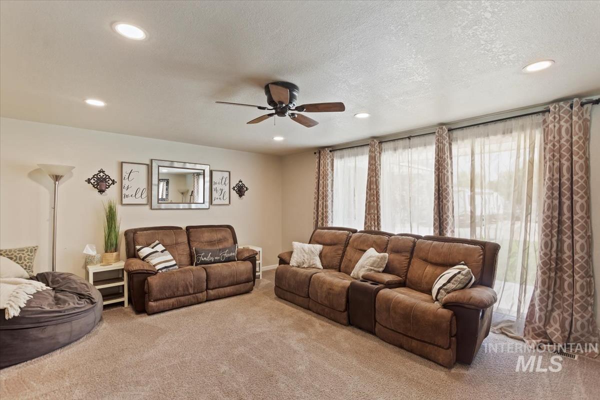 13712 Jarett Street Caldwell, ID 83607 - Photo 23 of 39 Carpeted living room with a textured ceiling, ceiling fan, and recessed lighting