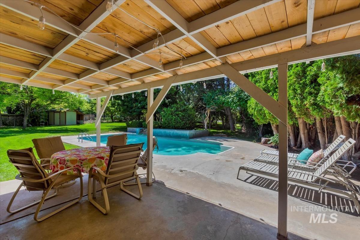 13712 Jarett Street Caldwell, ID 83607 - Photo 32 of 39 View of swimming pool with a shed, a patio, view of scattered trees, and a lawn
