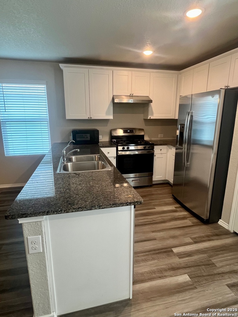 10418 Midsummer Meadow Converse, TX 78109 - Photo 9 of 24 a kitchen with stainless steel appliances granite countertop a sink stove and refrigerator