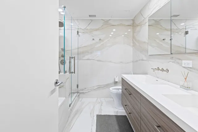 a bathroom with a sink a toilet and shower