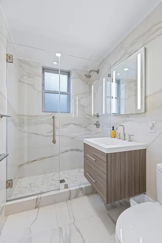 a bathroom with a sink mirror vanity and toilet