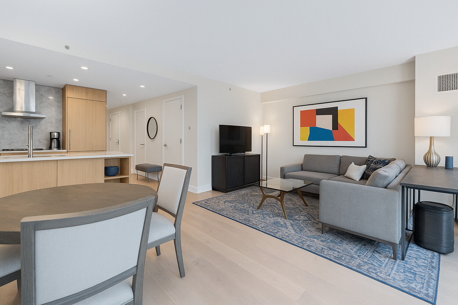 27 West 19th Street, Unit 12 Manhattan, NY 10011 - Photo 4 of 18 a living room with furniture a flat screen tv and kitchen view