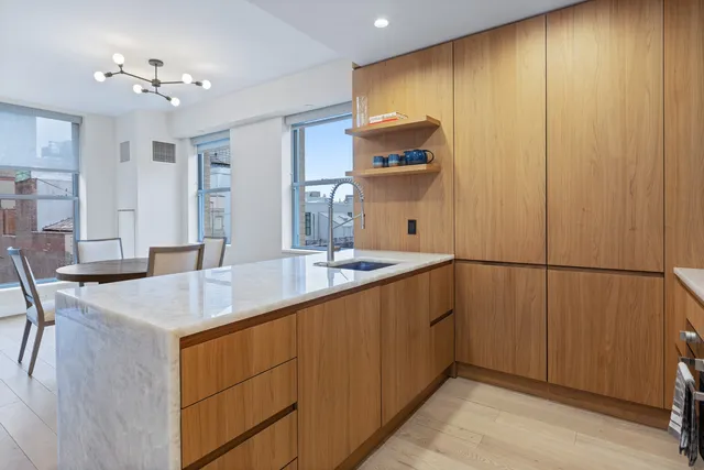 a kitchen with sink a refrigerator and chairs