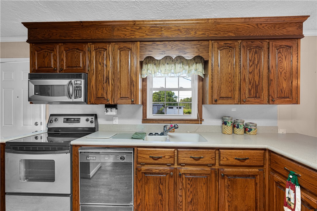 307 Calhoun Road Belton, SC 29627 - Photo 24 of 30 Functional kitchen with ample oak cabinetry and a double basin sink, perfect for daily meal prep.