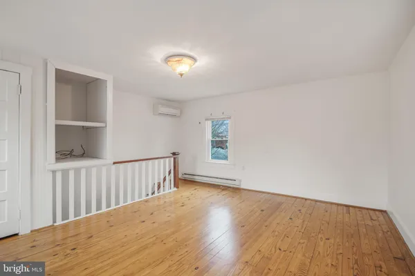 a view of a hallway with wooden floor and a window