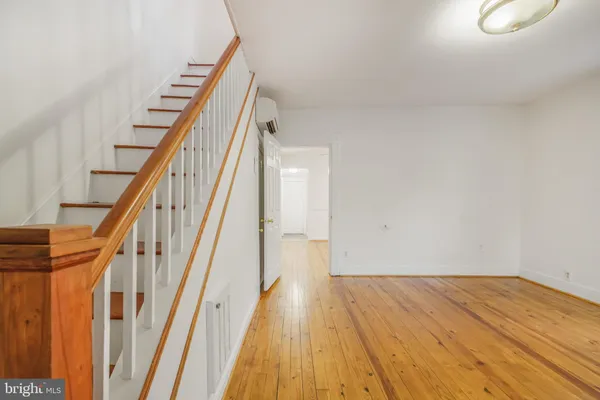 a view of a hallway with wooden floor and staircase