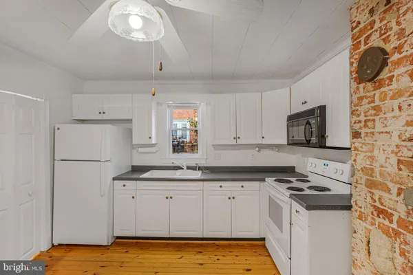 a kitchen with granite countertop a sink stove and refrigerator