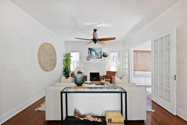 a living room with furniture a clock on wall and a window