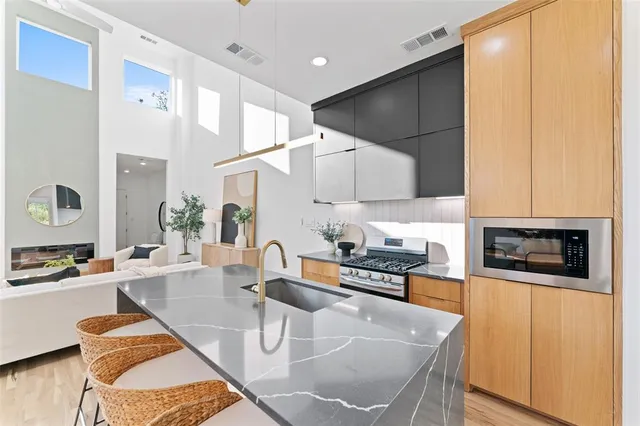 a kitchen with stainless steel appliances granite countertop a sink a stove and white cabinets
