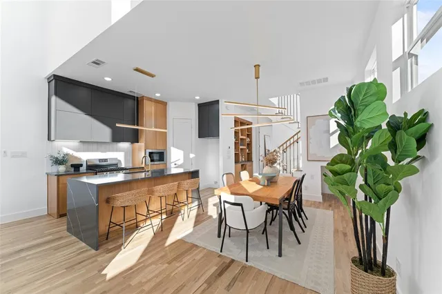 a kitchen with granite countertop white cabinets stainless steel appliances and wooden floor
