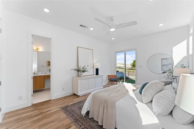 a bedroom with a large bed and wooden floor