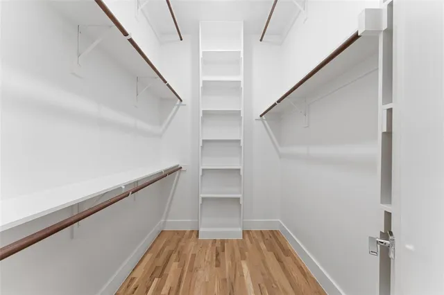 a view of walk in closet with wooden floor