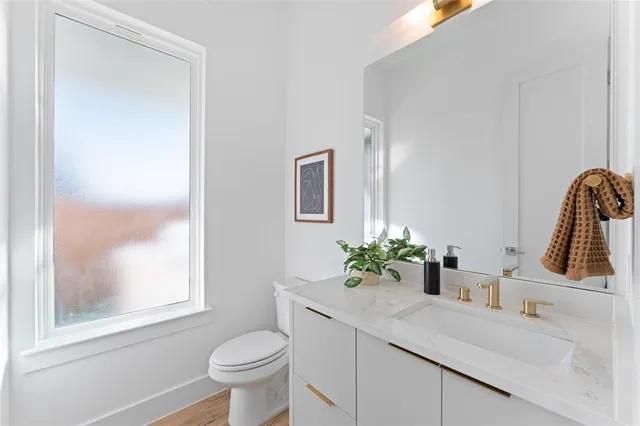 a bathroom with a toilet a sink and a window