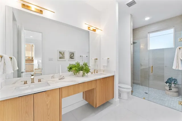 a bathroom with a sink double vanity granite tub shower and a mirror