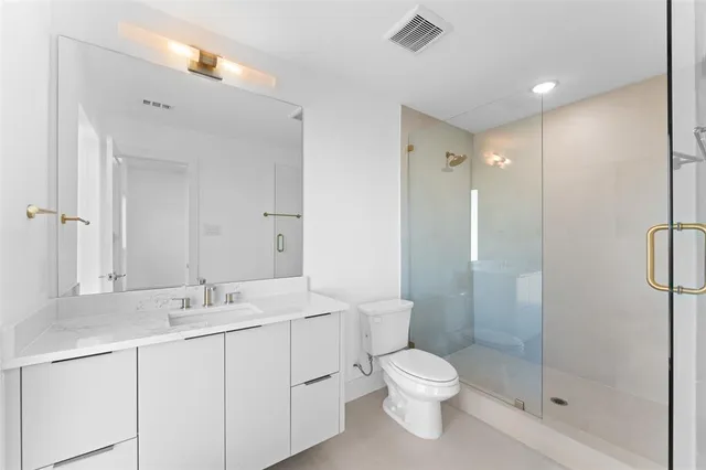 a bathroom with a toilet sink shower and a mirror