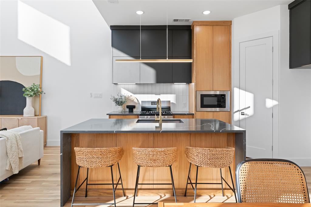 2313 South Vernon Avenue Dallas, TX 75224 - Photo 10 of 40 a kitchen with a table chairs refrigerator and microwave