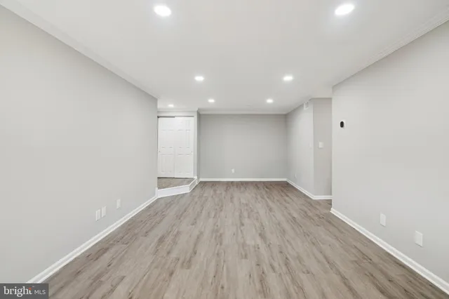 a view of an empty room with wooden floor
