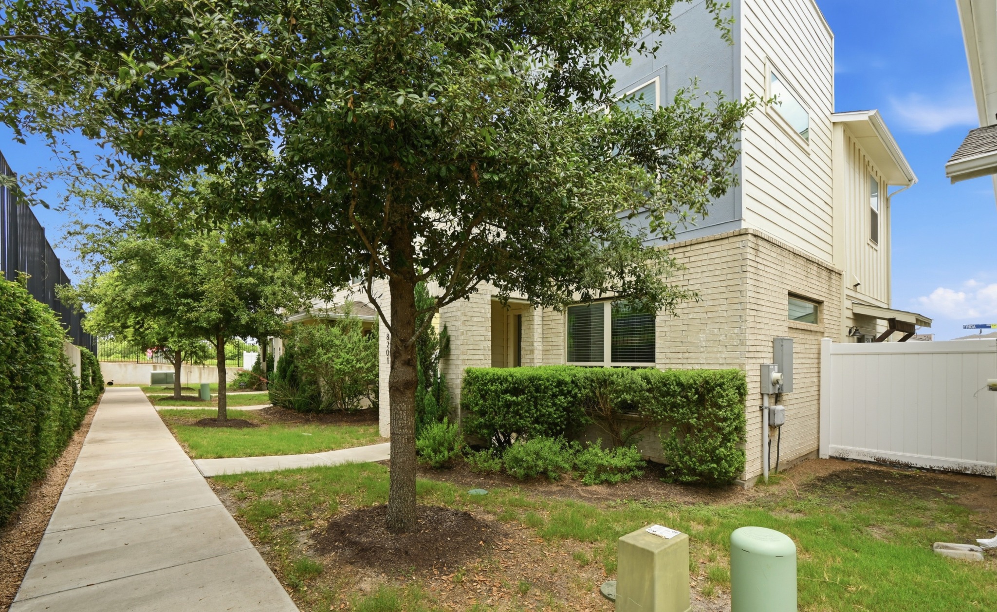 8201 Frida Bend Austin, TX 78744 - Photo 4 of 29 Mature trees and lush landscaping adorn the inviting facade of this contemporary home.